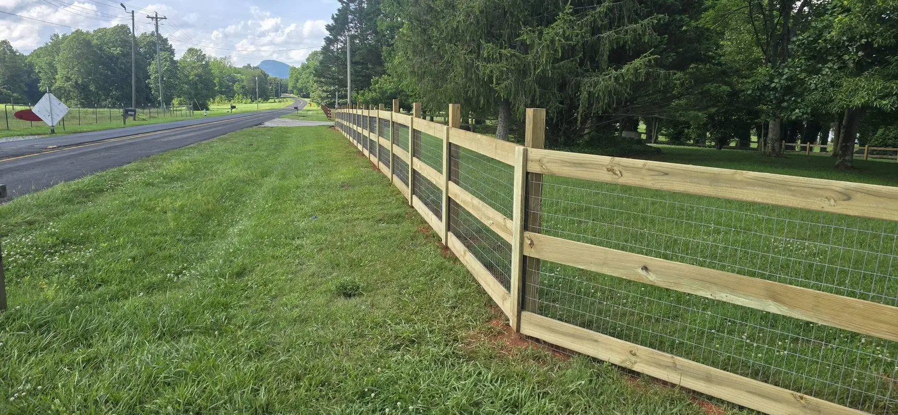 Wood and wire fencing following the edge of a residential property