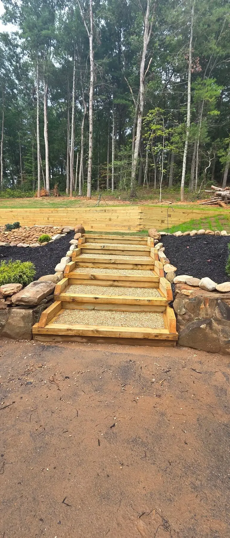 Front view of custom timber and gravel landscape steps built into a hillside