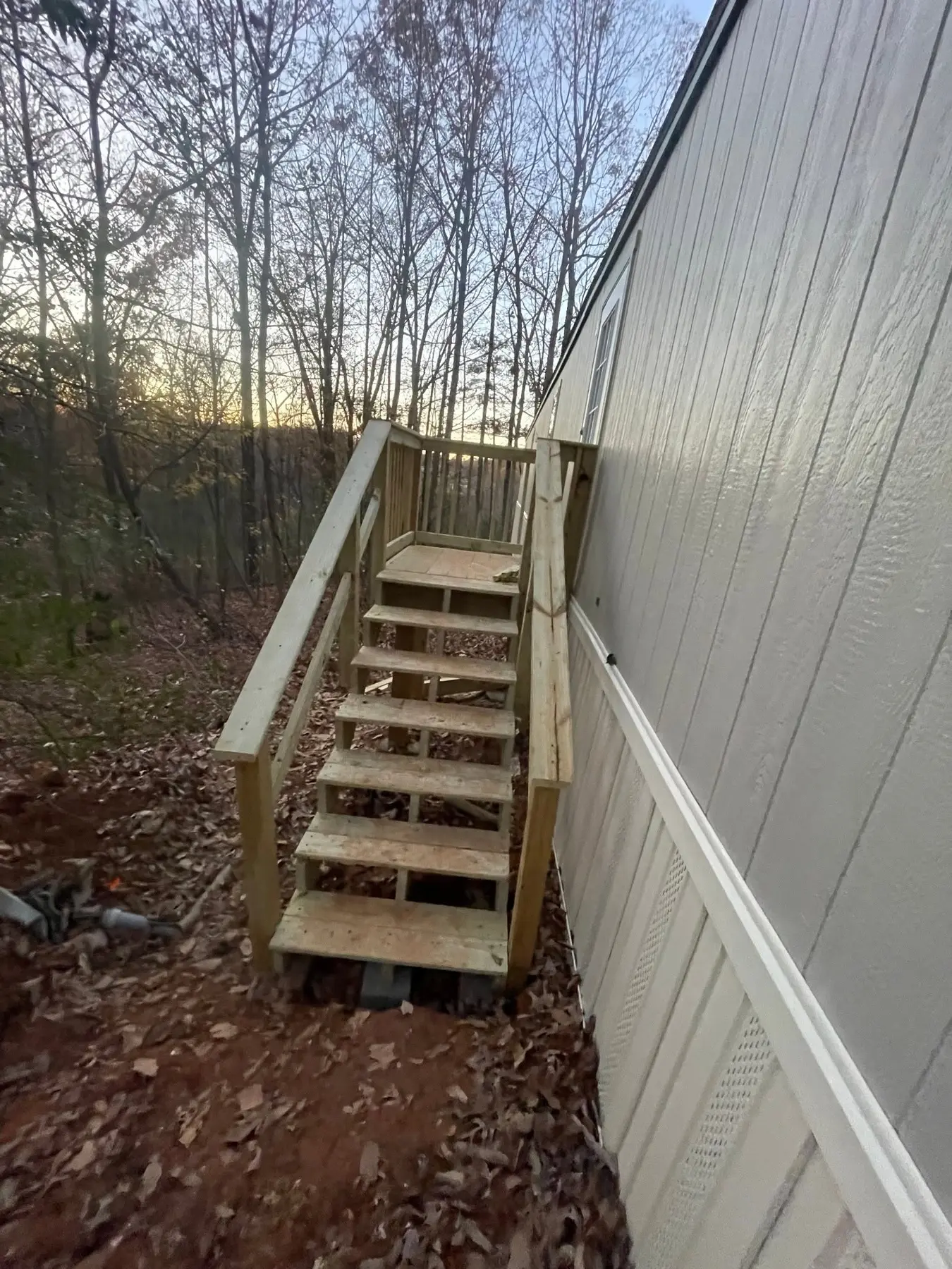 Compact elevated side-entry landing with wooden stairs and handrails